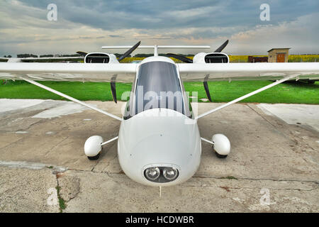 Région de Kiev, Ukraine - le 19 juillet 2014 : Léger bimoteur privé avion stationné sur un aérodrome avec ciel d'orage l'arrière-plan - vue avant Banque D'Images