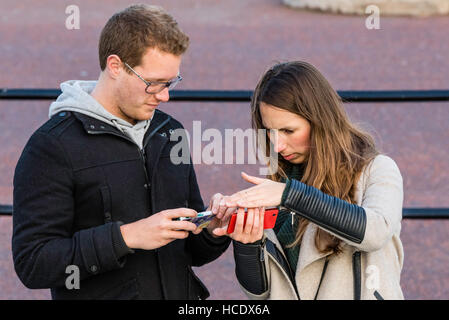 Un couple à la recherche d'images avec l'intérêt qu'ils ont prises sur leur téléphone mobile Banque D'Images