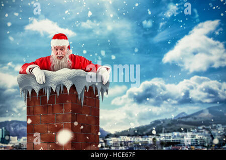 Image composite de santa claus peeking over wall Banque D'Images