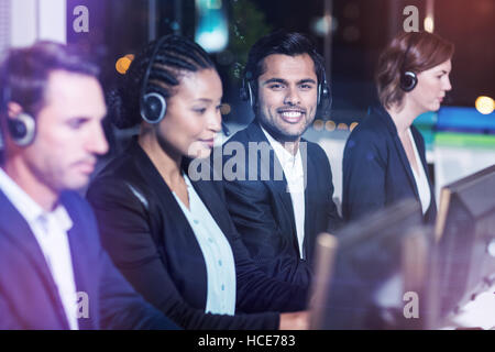 Avec l'aide de collègues casques computer at office Banque D'Images