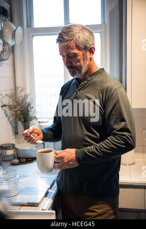 L'homme de préparer un café noir dans la cuisine Banque D'Images