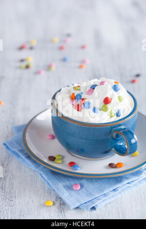 Café avec la crème fouettée et des pastilles de chocolat colorés Banque D'Images