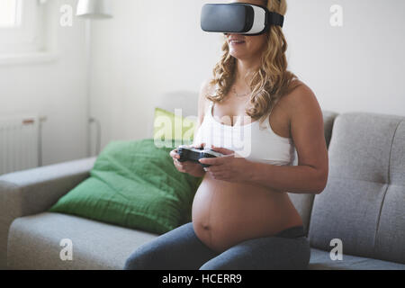 Beautiful pregnant woman enjoying VR Banque D'Images