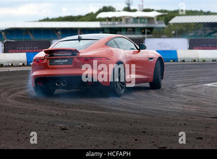 Démonstration effectuée à la dérive à bord d'une Jaguar F-Type S dans la zone adrénaline du Silverstone Classic 2016. Banque D'Images