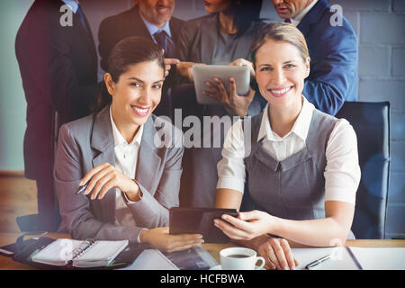 Businesswomen using digital tablet in conference room Banque D'Images