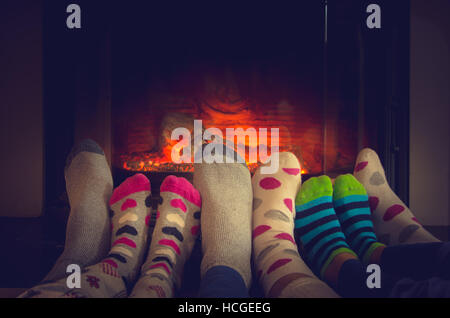 Pieds dans des chaussettes de toute la famille et de détente par réchauffement bon feu Banque D'Images