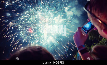 Woman enjoying fireworks et prenant des photos de la célébration Banque D'Images