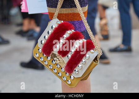 Femme avec Hibourama avec sac fourrure rouge et goujons avant Cristiano Burani fashion show, Milan Fashion Week street style, 2016 Banque D'Images