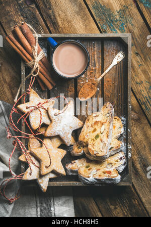 En cacao mug avec Noël gingerbread cookies en forme d'étoile et des morceaux de gâteau Stollen en plateau en bois plus rustique en arrière-plan, Vue de dessus, vertica Banque D'Images