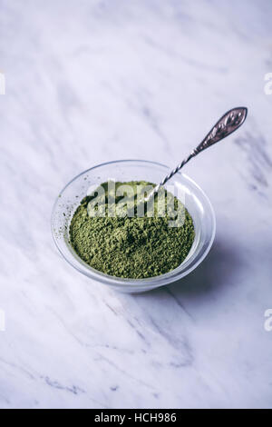 Le thé vert matcha en poudre dans un petit bol en verre Banque D'Images