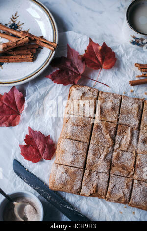 Gâteau blondies au four saupoudré de sucre à la cannelle sur une table de marbre blanc Banque D'Images