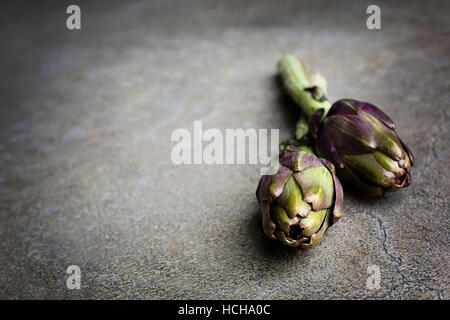 Artichauts frais sur fond gris Banque D'Images