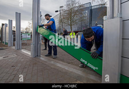 Brême, Allemagne. Le 08 mai 2016. Les ouvriers du montage de la nouvelle barrière de protection contre les inondations mobile lors d'une manifestation devant le stade Weser à Brême, Allemagne, 08 décembre 2016. Le mur est conçu pour compléter une deuxième, mur permanent autour du stade de foot en cas de crues éclair. Photo : Ingo Wagner/dpa/Alamy Live News Banque D'Images