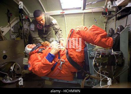 Dans un United States Air Force centrifuger à Brooks Air Force Base, Texas, le sénateur américain John H. Glenn Jr. (Démocrate de l'Ohio) est attaché par le Johnson Space Center's Carlous Gillis (à gauche) le 19 février 1998. Le spécialiste de mission STS-95 a réalisé deux sessions de neuf minutes dans la centrifugeuse, d'un seuil de 3 G-forces, ou trois fois son propre poids. Crédit obligatoire : Steve Thurow/USAF via CNP /MediaPunch Banque D'Images