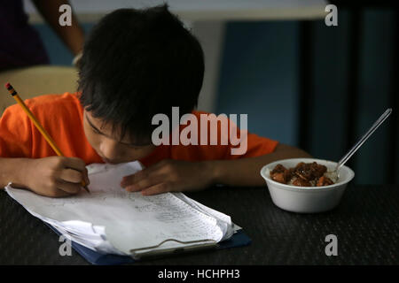 Quezon City, Philippines. 8e Dec 2016. Un garçon enregistre son nom pour un repas gratuit au 'Duterte's Kitchen' dans la ville de Quezon, Philippines, le 8 décembre 2016. La cuisine de 'Duterte', un centre d'alimentation nommé d'après le Président philippin Rodrigo Duterte, offre des repas gratuits aux sans-abri. Le gouvernement des Philippines visant à réduire les taux de pauvreté à entre 13 et 15 pour cent d'ici 2022. © Rouelle Umali/Xinhua/Alamy Live News Banque D'Images