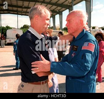 STS-95 Spécialiste de charge utile de John H. Glenn Jr. (à droite), le sénateur de l'Ohio, embrasse son fils, David, après l'atterrissage au Centre spatial Kennedy d'atterrissage à Cap Canaveral en Floride à bord d'un jet T-38 le 26 octobre 1998. À peine visible derrière eux est la fille de Glenn, Lyn. Glenn et autres membres d'équipage ont volé dans l'KSC pour faire les derniers préparatifs pour le lancement. Ciblé pour le décollage à 2 heures, le 29 octobre, la mission STS-95 comprend des charges utiles de recherche tels que l'observation solaire Spartan véhicule spatial déployable, le télescope spatial Hubble systèmes orbitaux, la plate-forme d'essai extrême International Ultrav Banque D'Images