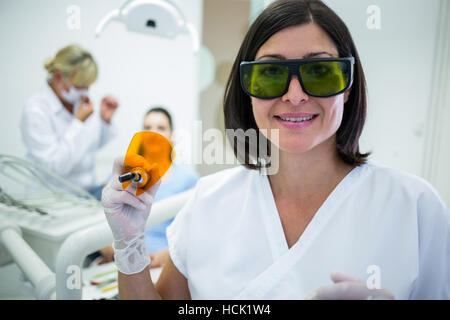 Dentiste tenant une lumière uv durcissement dentaire Banque D'Images