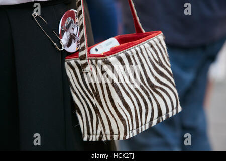 Femme avec sac noir et blanc zebrine avant de Salvatore Ferragamo fashion show, Milan Fashion Week street style, le 25 septembre dernier. Banque D'Images