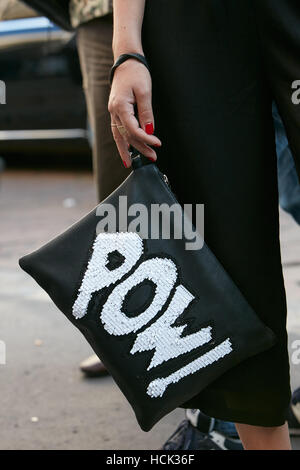 Femme avec sac en cuir noir avec Pow ! L'Écriture en blanc avant de Salvatore Ferragamo fashion show, Milan Fashion Week street style ? Banque D'Images