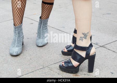 Femme avec talons hauts chaussures en cuir noir et de tatouage avant Genny fashion show, Milan Fashion Week street style le 22 septembre. Banque D'Images