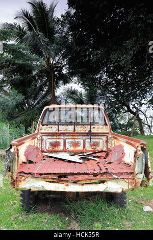 Vue arrière du rusty-wormy-rotten reste d'une vieille camionnette abandonnée dans le parc de l'école locale et l'église du village à l'Olal N.ti Banque D'Images