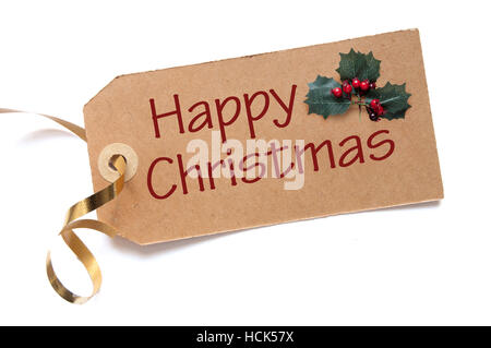 Joyeux Noël à la main sur une étiquette avec des feuilles de houx Banque D'Images