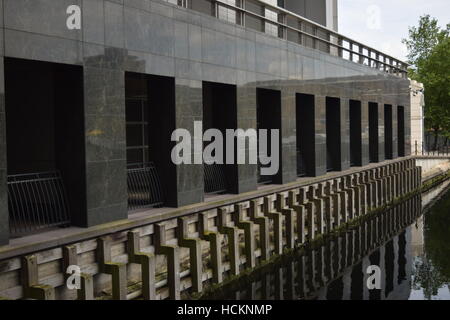 De grandes fenêtres avec des grilles métalliques dans un bâtiment sur l'eau du quartier d'affaires Canary Wharf de Londres Banque D'Images