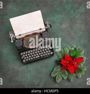 Vintage typewriter avec décoration de Noël conifère brunchs et poinsettia rouge fleurs. Joyeux Noël ! Banque D'Images