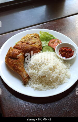 Penyek Ayam Nasi ou connu sous le nom de riz au poulet avec poulet rôti et salade sur une assiette blanche Banque D'Images