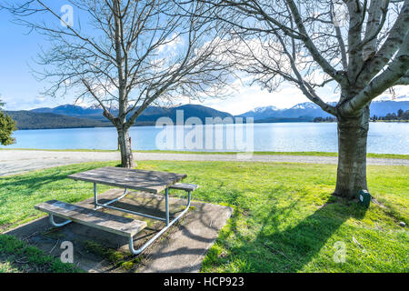 Table en bois et chaise en face à vue sur le lac Te Anau, Nouvelle-Zélande Banque D'Images