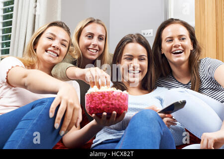 Groupe de femmes amis adolescents regardent la télévision à la maison Banque D'Images