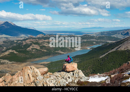 Une femme prend une pause de la randonnée le sentier dans le Parc National El Chalten pour apprécier la vue, le lac se disputaient, Patagonie, Argentine Banque D'Images