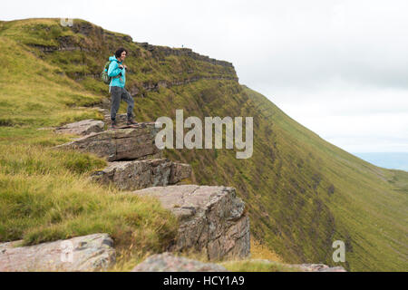 Une femme donne à une crête en marchant à Lyn y Fan Fawr dans les Brecon Beacons, dans le sud du Pays de Galles, Royaume-Uni Banque D'Images