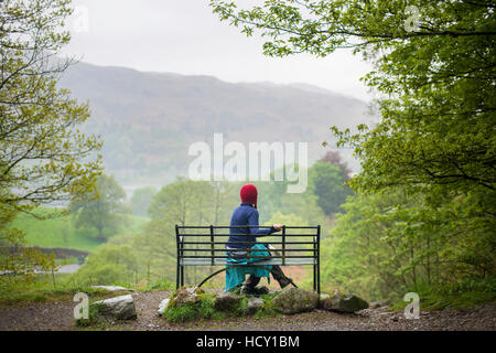 Une femme repose sur un banc en marchant dans le district du lac Près de Grasmere, Cumbria, Royaume-Uni Banque D'Images