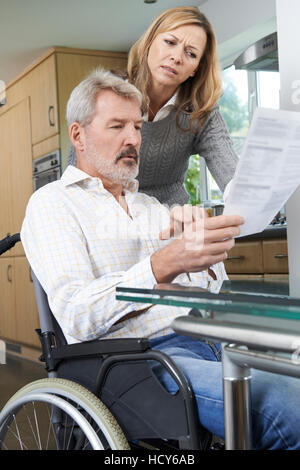 Couple avec Mari en fauteuil roulant pour lire une lettre envoyée Banque D'Images