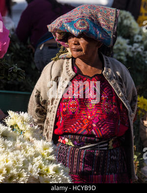 Femme Maya quiche en costume traditionnel vente de fleurs sur les marches de l'église de Santo Tomas à Chichicastenango, Guatemala. Banque D'Images