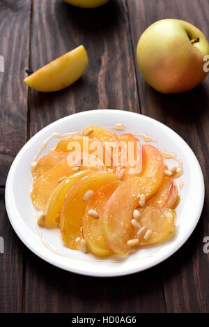 Des tranches de pommes caramélisées sucrées on white plate Banque D'Images