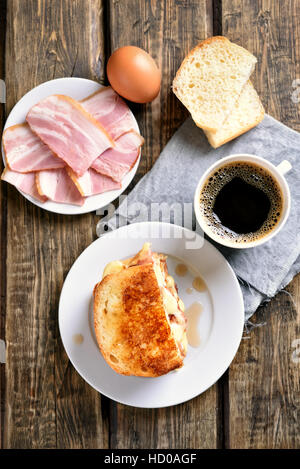 Le petit-déjeuner sandwich toast avec du fromage, du jambon et du café sur fond de bois, vue du dessus Banque D'Images