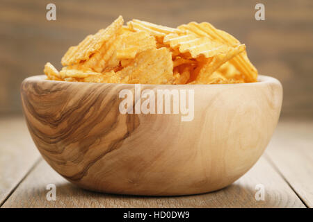 Chips de pomme de terre ridée de paprika saveur dans bol en bois Banque D'Images