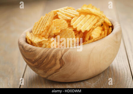 Chips de pomme de terre ridée de paprika saveur dans bol en bois Banque D'Images