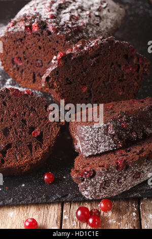 Tranches de gâteau au chocolat et aux canneberges farci macro sur la table verticale. Banque D'Images
