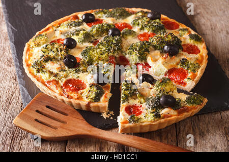 Salé tarte de poulet, brocoli, tomates et olives close-up sur la table horizontale. Banque D'Images
