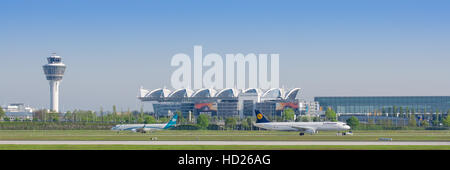 Vue panoramique de l'aéroport international de Munich avec terminal passager, tour de contrôle du trafic aérien et circulation sur les avions taxway Banque D'Images