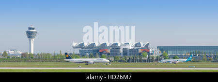 Vue panoramique de l'aéroport international de Munich avec la circulation au sol des avions de passagers et la borne et tour de contrôle de la circulation aérienne Banque D'Images