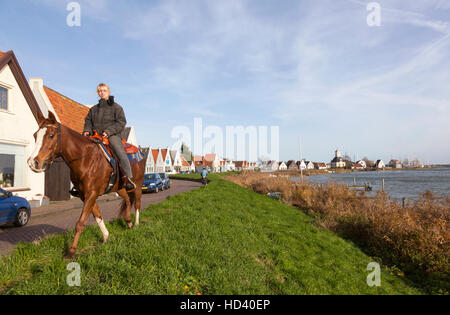 Petites maisons avec pièces en bois et une fille à cheval à durgerdam près d'Amsterdam aux Pays-Bas Banque D'Images