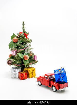 Jouet voiture rétro rouge porte une boîte avec un cadeau pour arbre de Noël. Banque D'Images