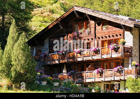 Swiss chalets traditionnels avec des fleurs sur les balcons de resort ville Zermatt en Suisse en été Banque D'Images