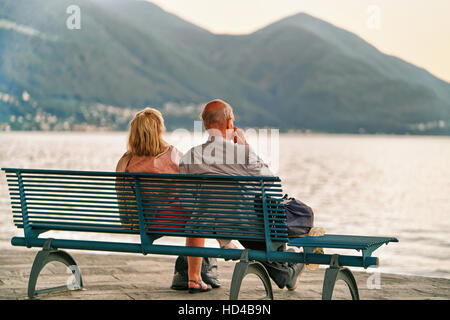 Couple assis sur le banc au remblai d'Ascona au bord du Lac Majeur, canton du Tessin suisse de Banque D'Images