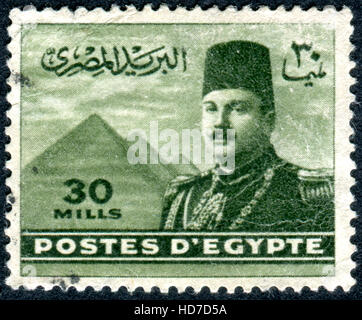 Égypte - circa 1947 : timbre imprimé en Egypte, présente le roi Farouk en face des pyramides de Gizeh, vers 1947 Banque D'Images