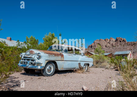 Début des années 50 Chevy voiture bleu clair avec rust abandonnés en ville fantôme du désert et film fixé à Techatticup Mine dans le Nevada près de la Route 66. Banque D'Images